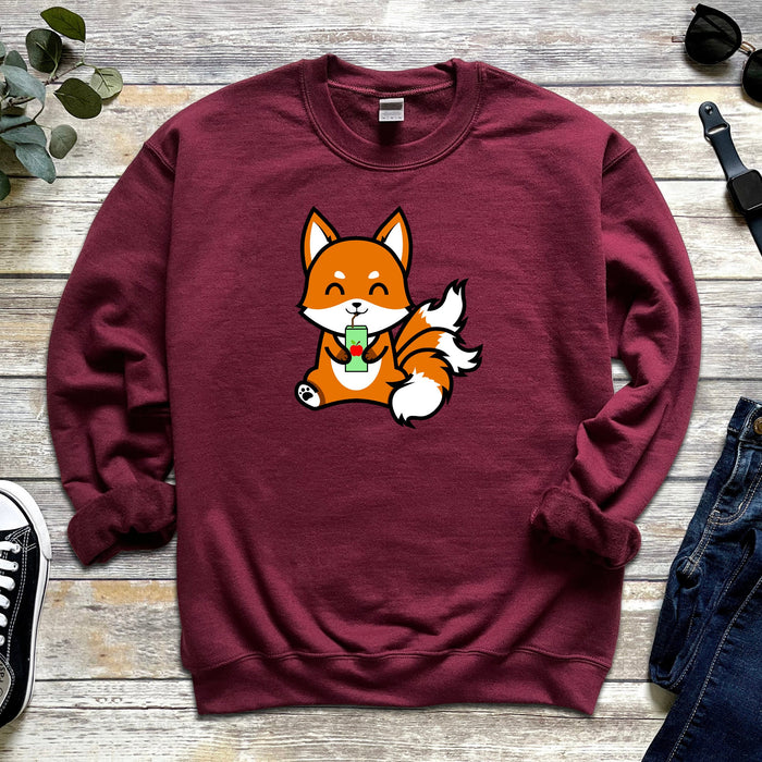 a red sweatshirt with a cartoon fox eating an apple