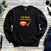 a black sweatshirt with a spoon and a bowl of soup on it