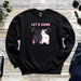 a black sweatshirt with a picture of a cat and a dog hanging from a tree