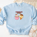 a blue sweatshirt with a picture of a cupcake and a donut on it