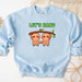 a blue sweatshirt with two slots hanging on a tree branch