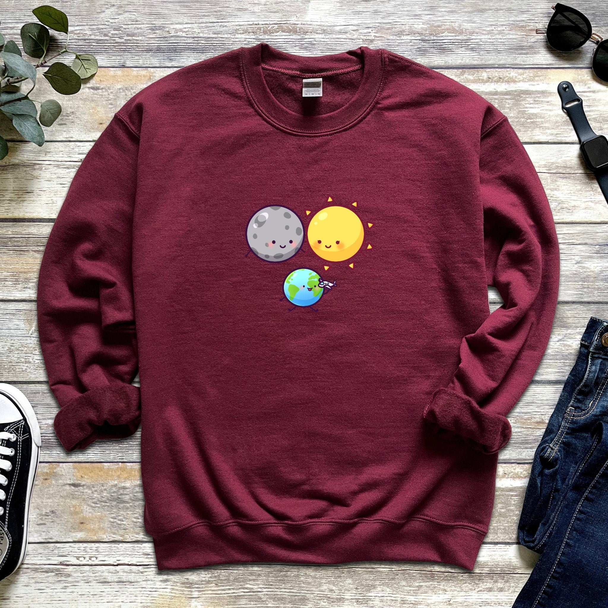 a sweatshirt with an image of a planet and a sun on it