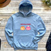 a blue hoodie with a cartoon of two poopies on it