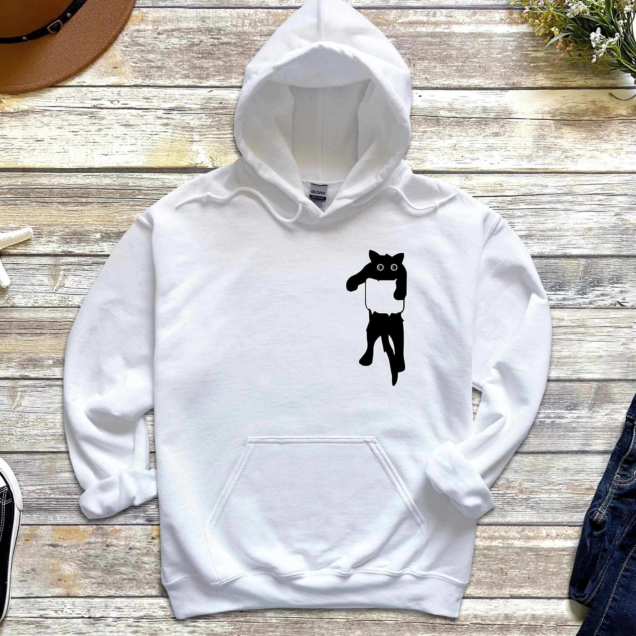 a white hoodie with a black cat on it