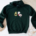 a green hoodie with an avocado and sheep on it