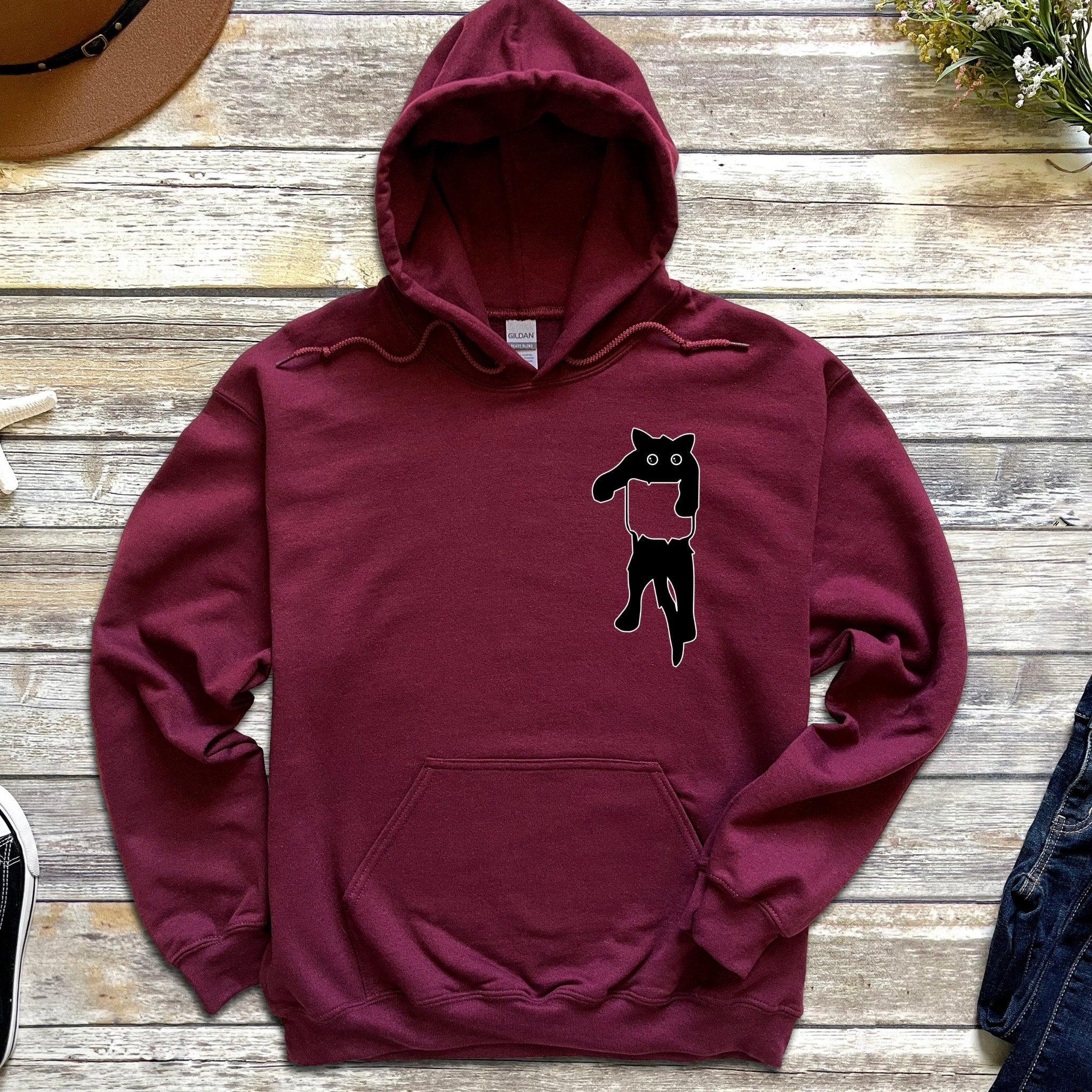 a maroon hoodie with a black cat on it
