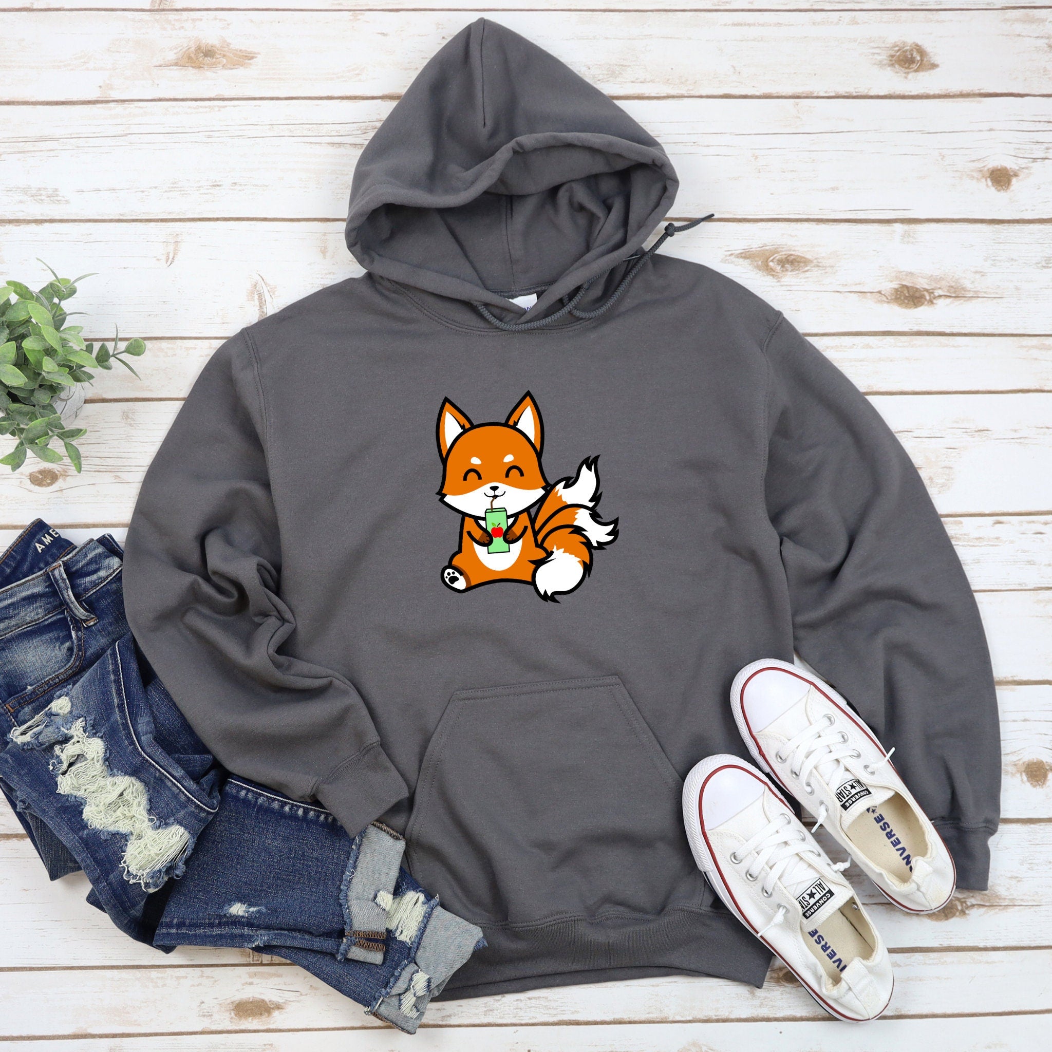 a gray hoodie with a cartoon fox eating an apple