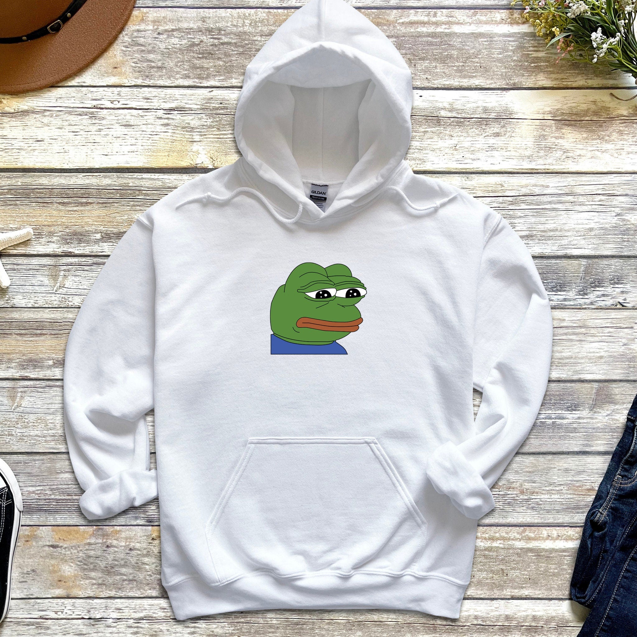 a white hoodie with a cartoon of a frog on it