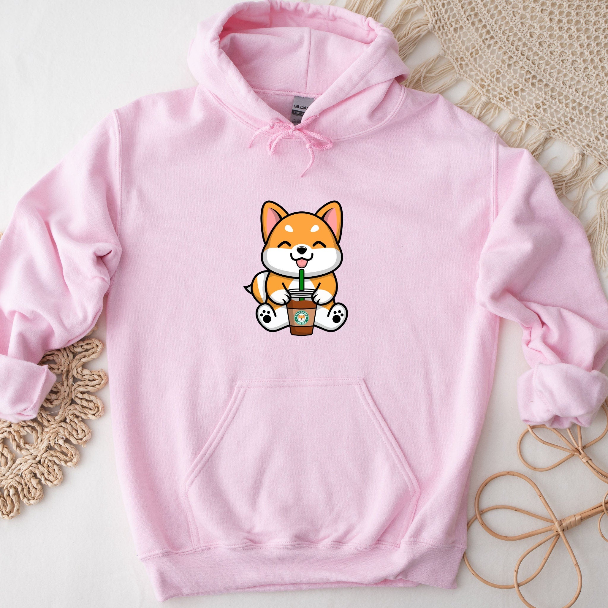 a pink hoodie with a cartoon cat holding a cup of coffee