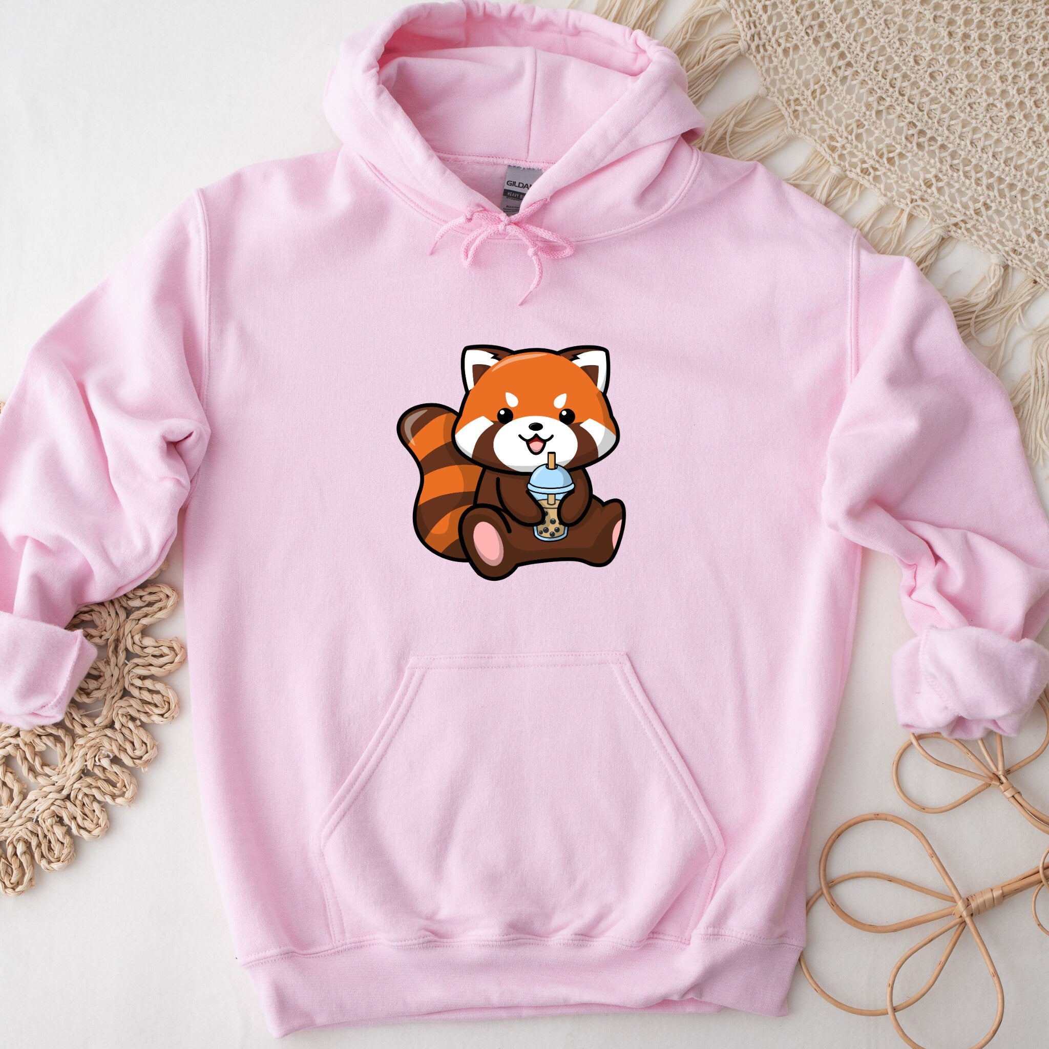 a pink hoodie with a picture of a red panda holding a cup