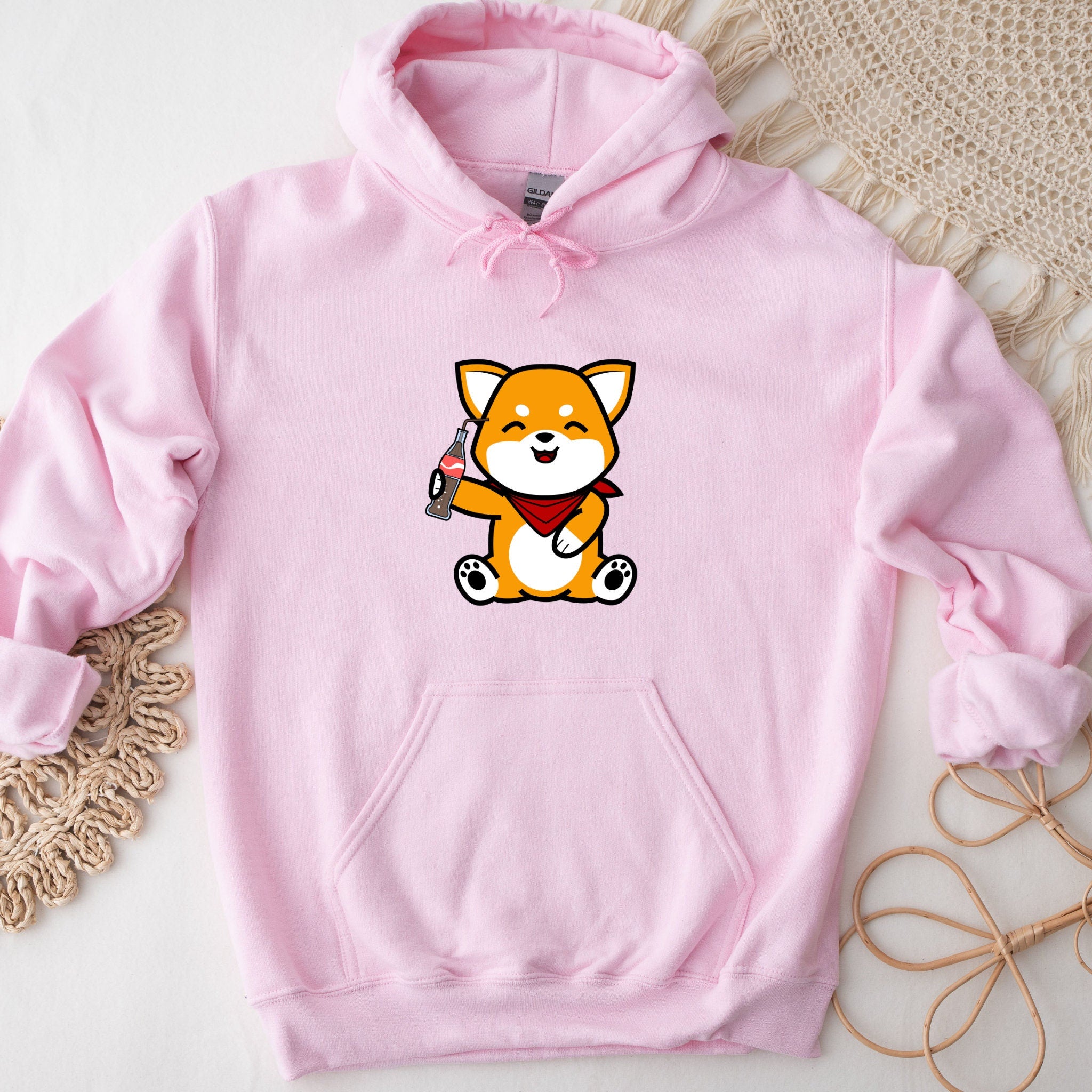 a pink hoodie with a cartoon fox holding a gun